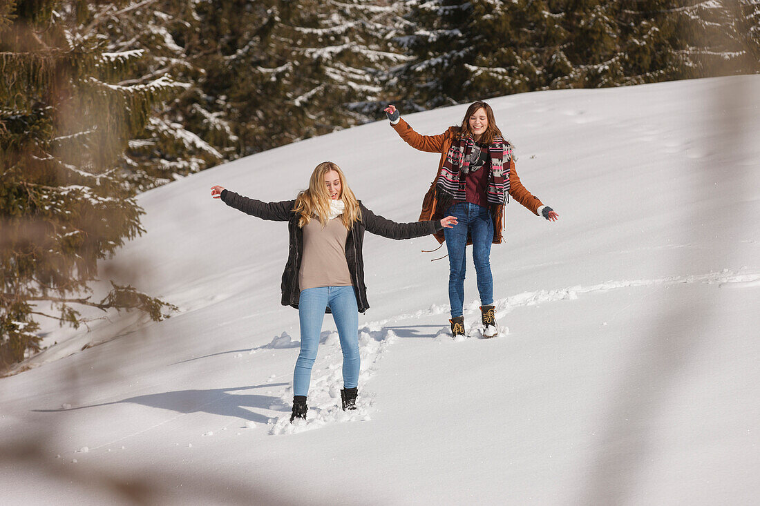 Two young women in snow, Spitzingsee, Upper Bavaria, Germany