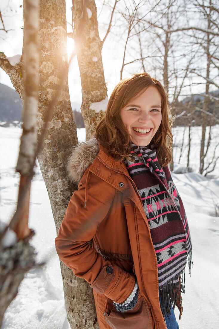 Young woman leaning against a tree, Spitzingsee, Upper Bavaria, Germany