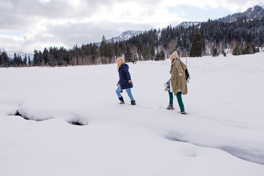 Two young women in snow, Spitzingsee, Upper Bavaria, Germany