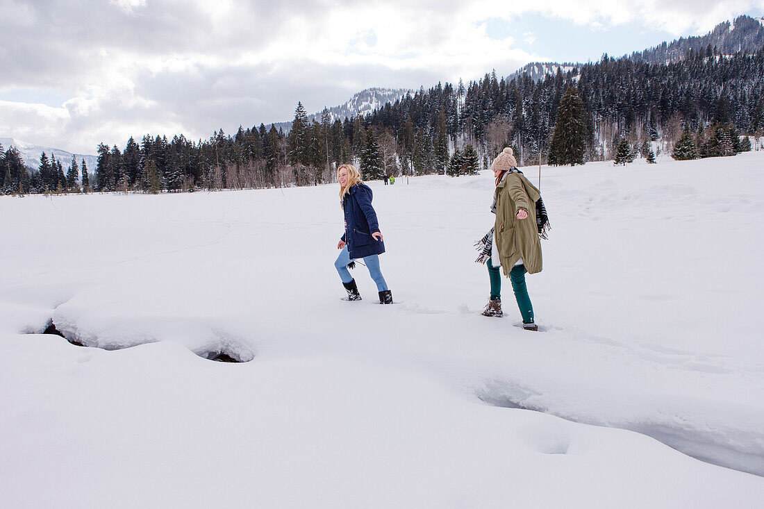 Zwei junge Frauen im Schnee, Spitzingsee, Oberbayern, Bayern, Deutschland