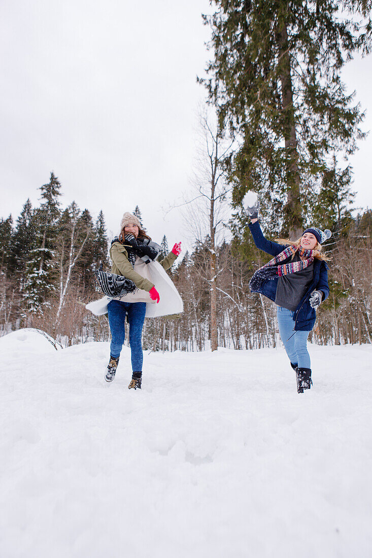 Two young women throwing snowballs, Spitzingsee, Upper Bavaria, Germany