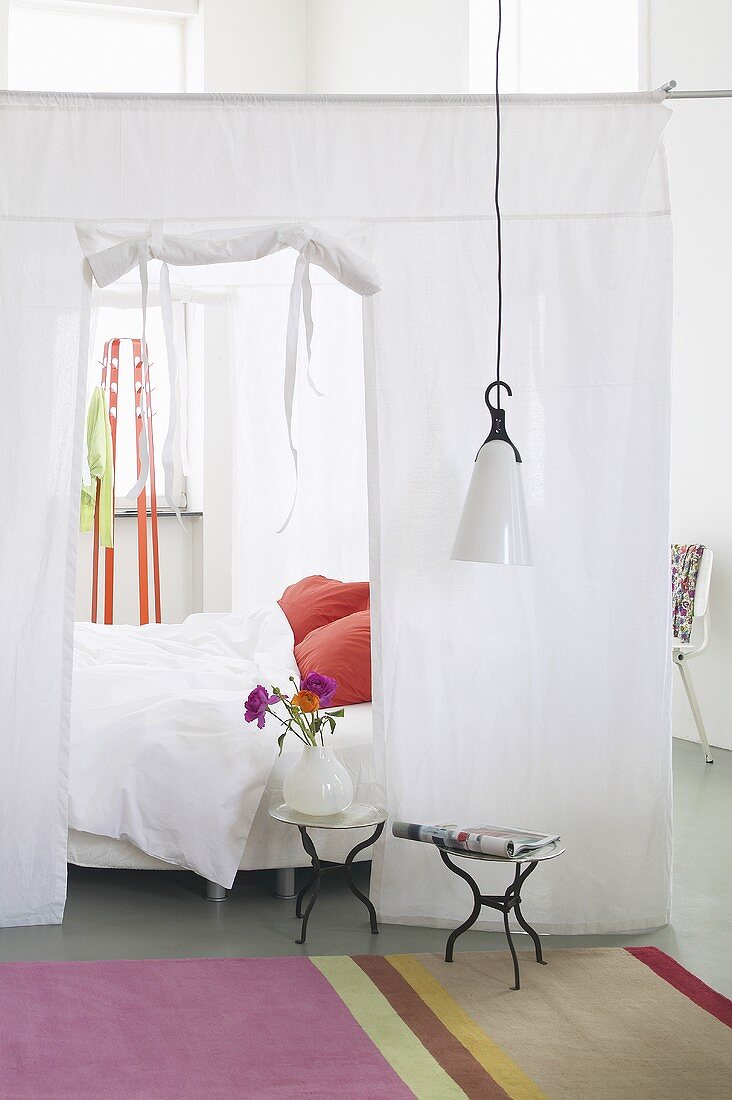 A fabric partition wall with an opening around a bed