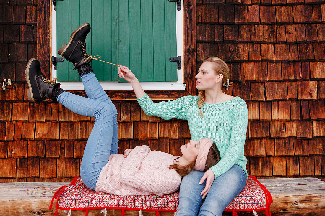 Two young women on a bench, Spitzingsee, Upper Bavaria, Germany
