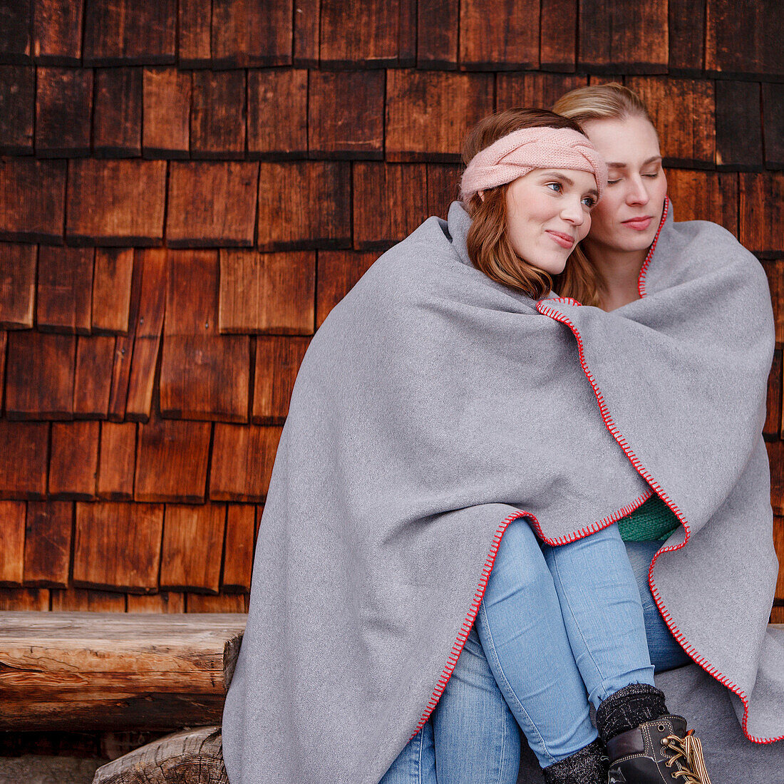 Two young women wrapped in a blanket, Spitzingsee, Upper Bavaria, Germany