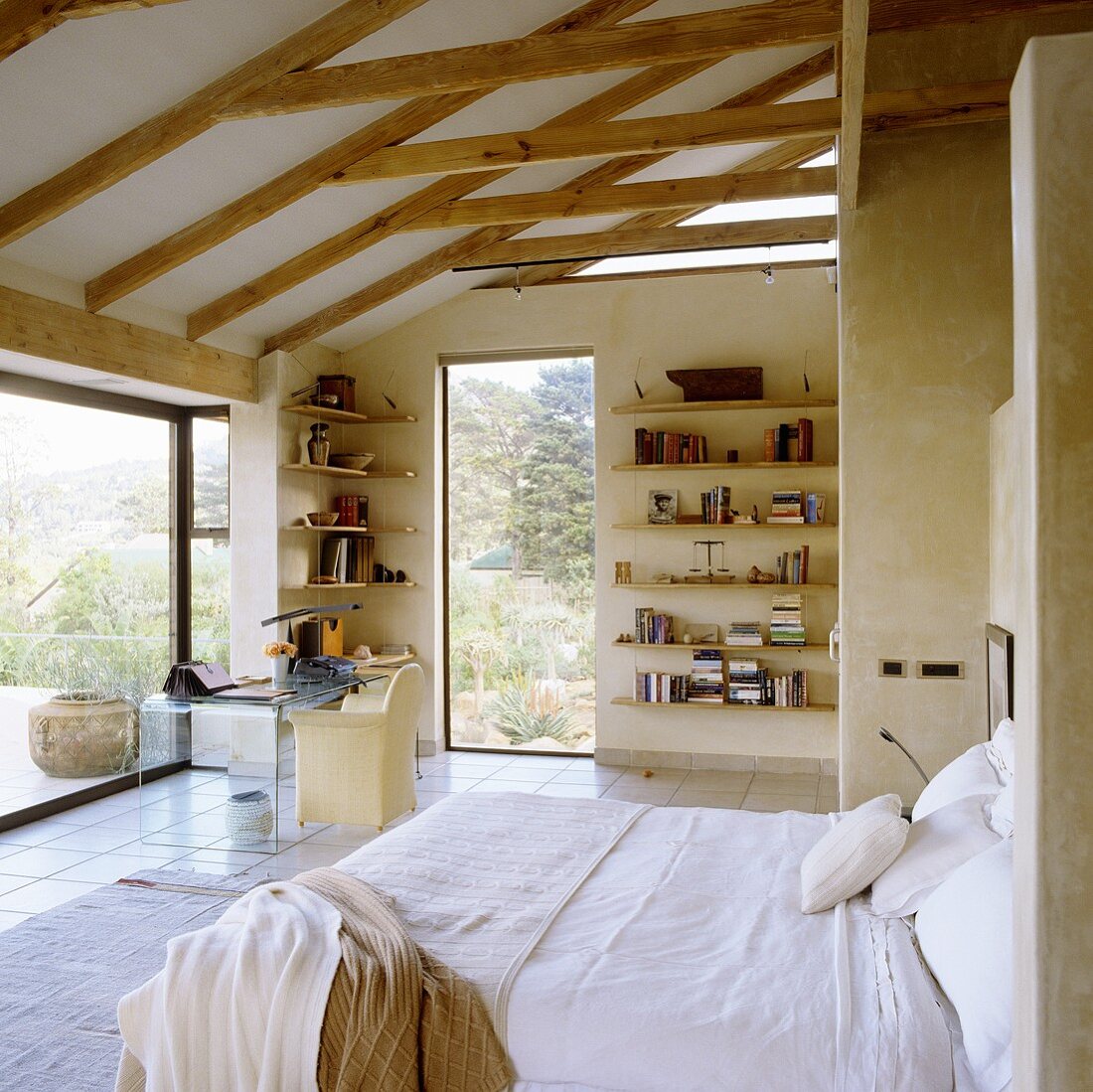 A bed with a view - a shelf on the wall under a wood beam ceiling