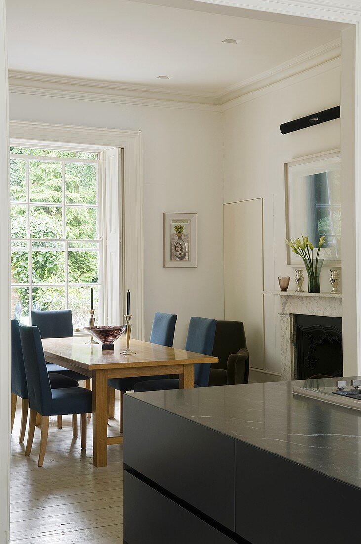 A dining area in front of a fireplace in an open living room with a view