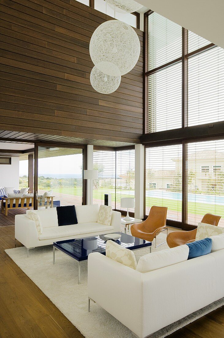 A white seating area with and designer lamp in a newly built villa with a glass facade