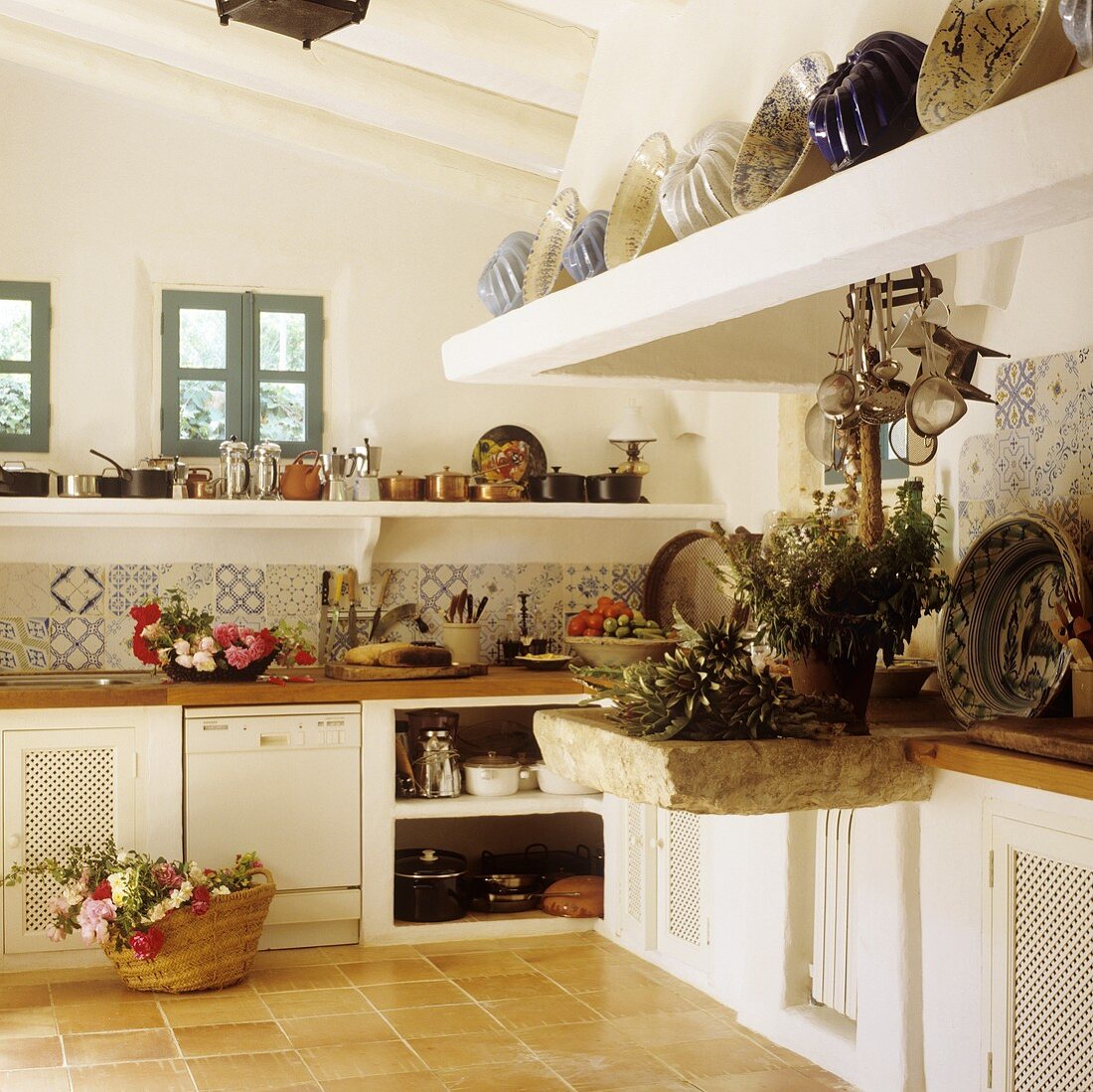 A kitchen in a Mediterranean country house with a kitchen counter and a stone-clad extractor