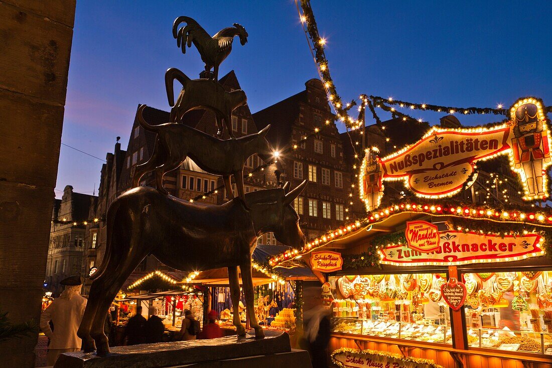 Statue of the Bremen town musicians and stalls at the Christmas market in Bremen, Germany, Europe