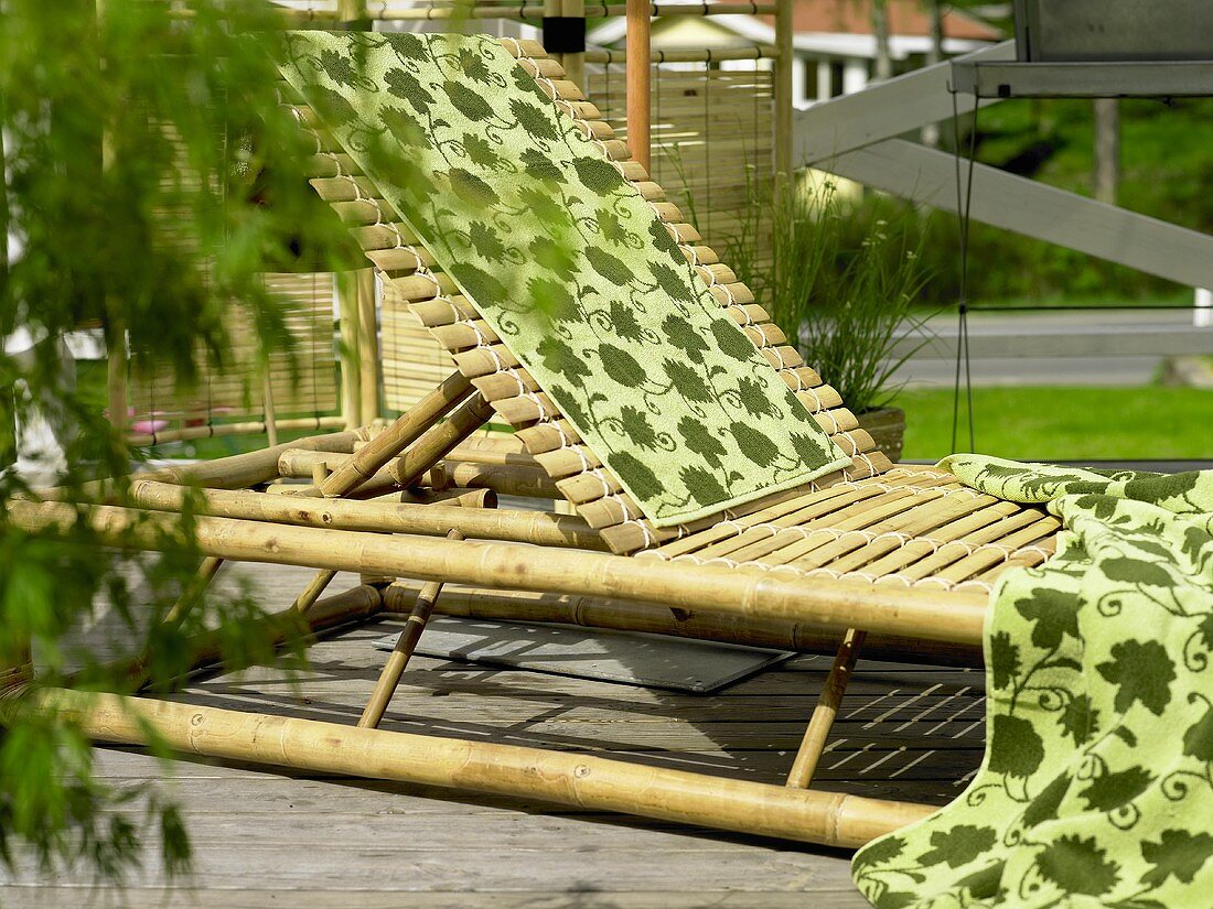 Rattan deck lounger with hand towels