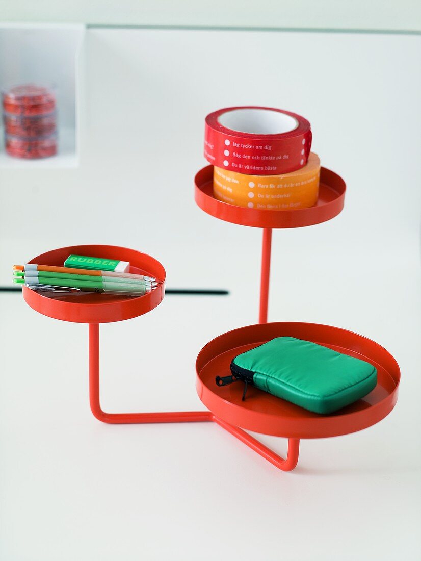 Rotes Metallgestell mit runden Tablett Ablagen und Schreibutensilien