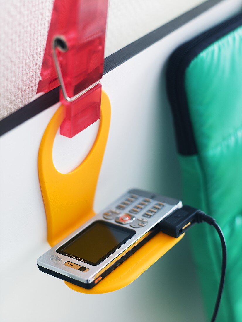 A mobile phone on a plastic yellow holder