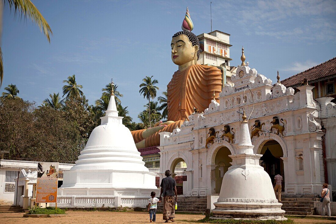 grandfather and child at Sri Lankas biggest Buddha Statue at Wewurukannala Vihara Temple near Dikwella, Pussalagoda, Sri Lanka, Walasgala