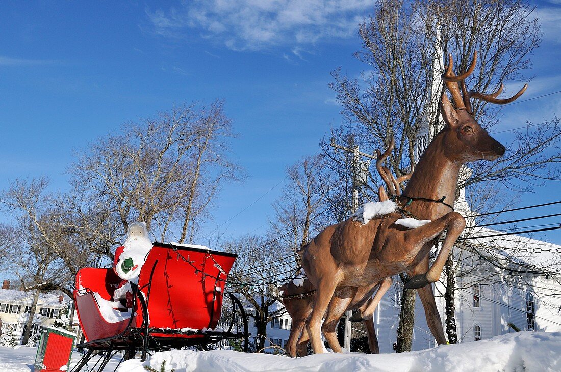 Santa in red sleigh with reindeer ouside in winter snow