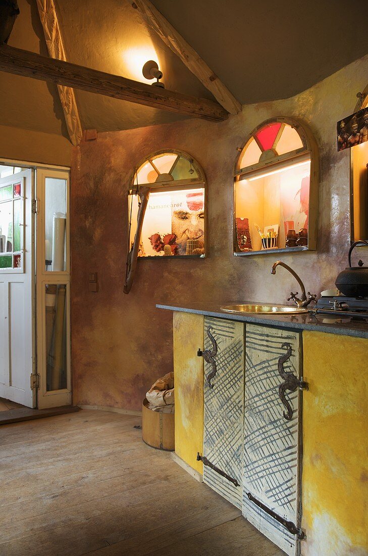 Küchenzeile und beleuchtete Wandnischen in rustikaler Küche