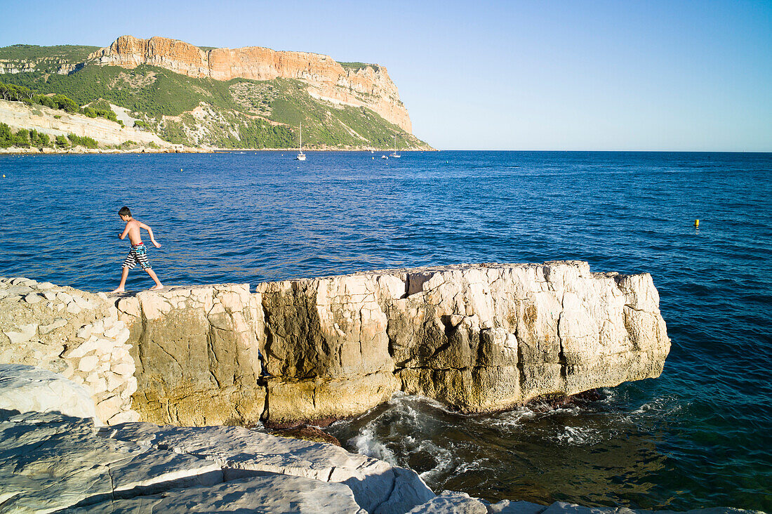 Junge auf Felsen, Cassis, Baie de Cassis, Bouches-du-Rhône, Frankreich