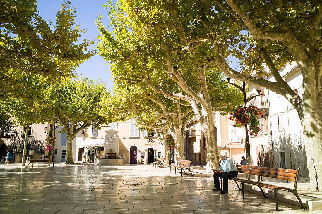 Man sat on the town square, Cassis, bay of Cassis, Bouches-du-Rhone, France