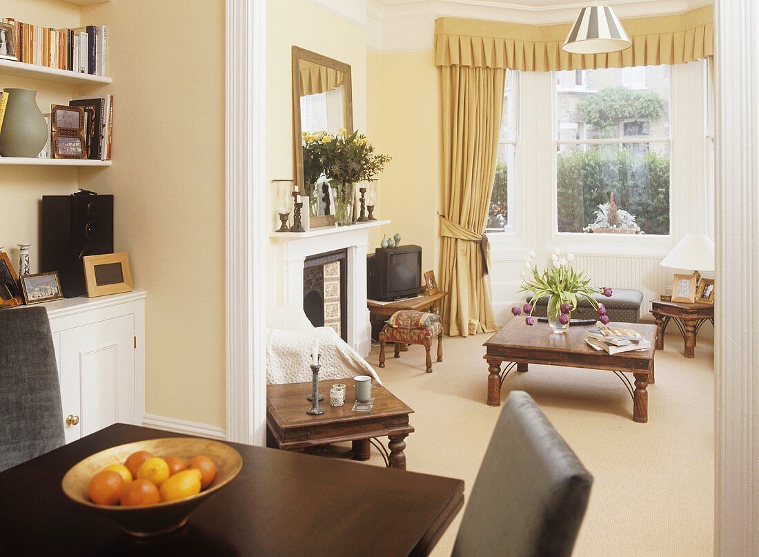 View through open doorway from dining room to sitting room decorated in neutral colours