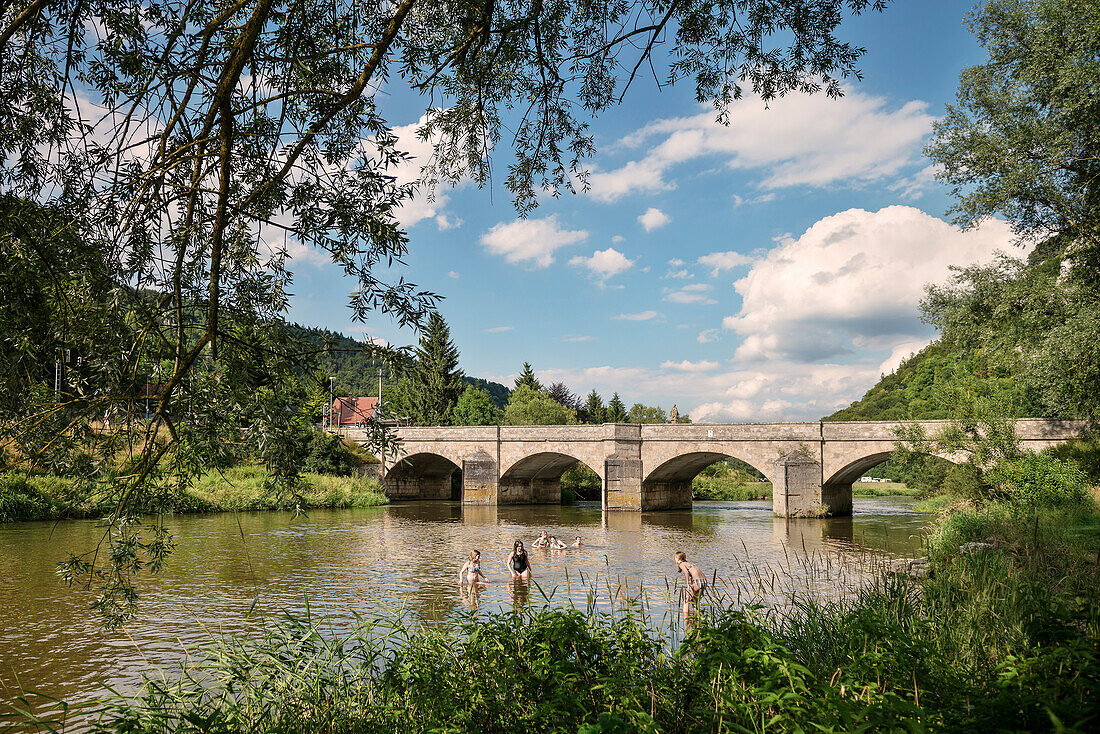 children swimming near the stone bridge in the Danube river, Upper Danube Nature Park, Sigmaringen, Tuttlingen, Zollernalb, Biberach, Swabian Alb, Baden-Wuerttemberg, Germany