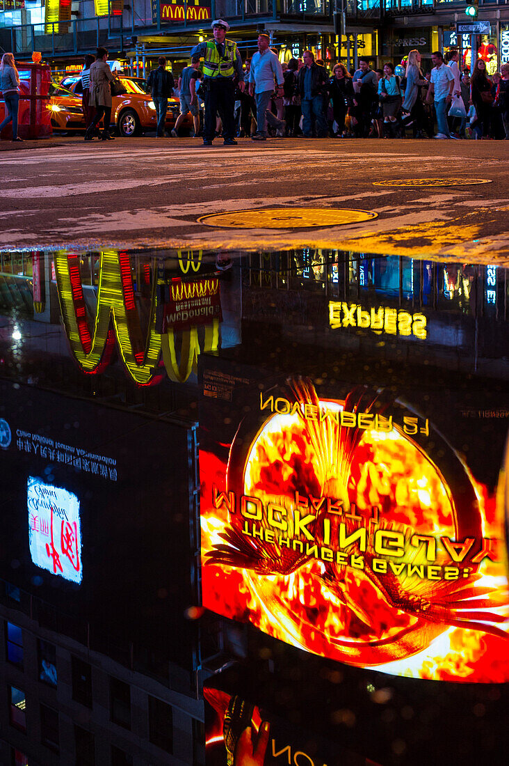 Reflection of a neon sign in a puddle, Times Square, Midtown, Manhattan, New York, USA