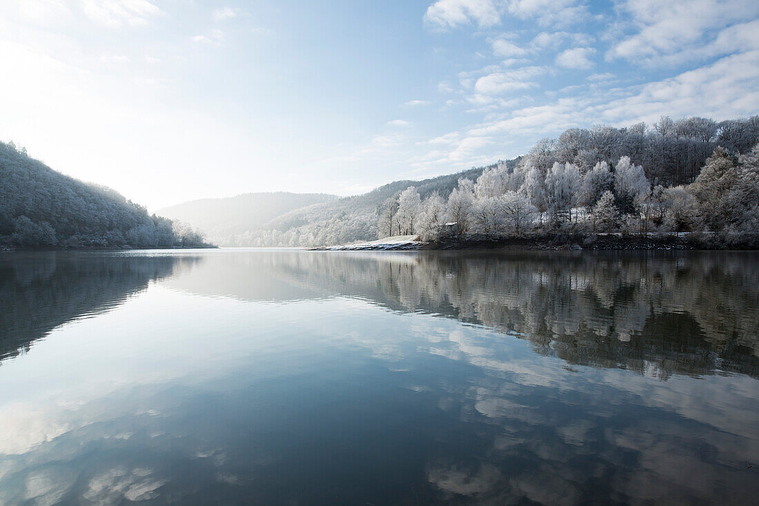 Reflection of a winter wonderland landscape in Lake Edersee, Lake Edersee, Hesse, Germany, Europe