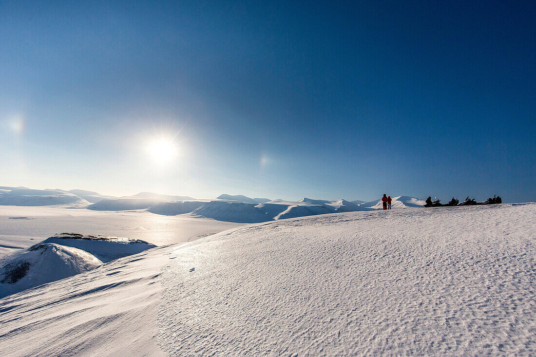 Personen in der winterlichen Landschaft von Spitzbergen mit Schneemobilen, Spitzbergen, Svalbard, Norwegen