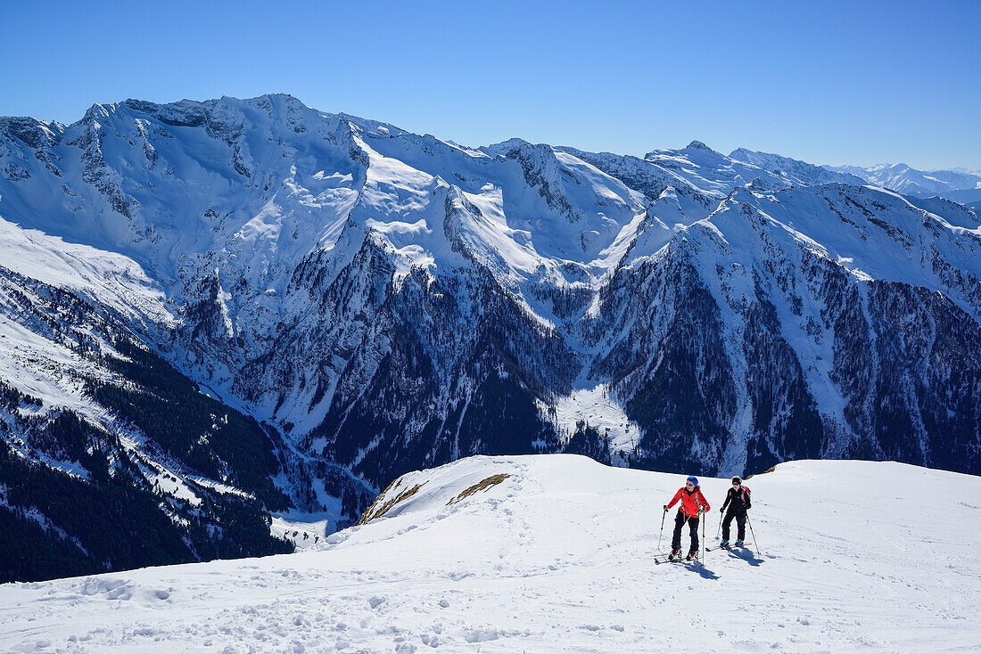 Two women back-country skiing ascending towards Gammerspitze, Zillertal Alps in the background, Gammerspitze, valley of Schmirn, Zillertal Alps, Tyrol, Austria