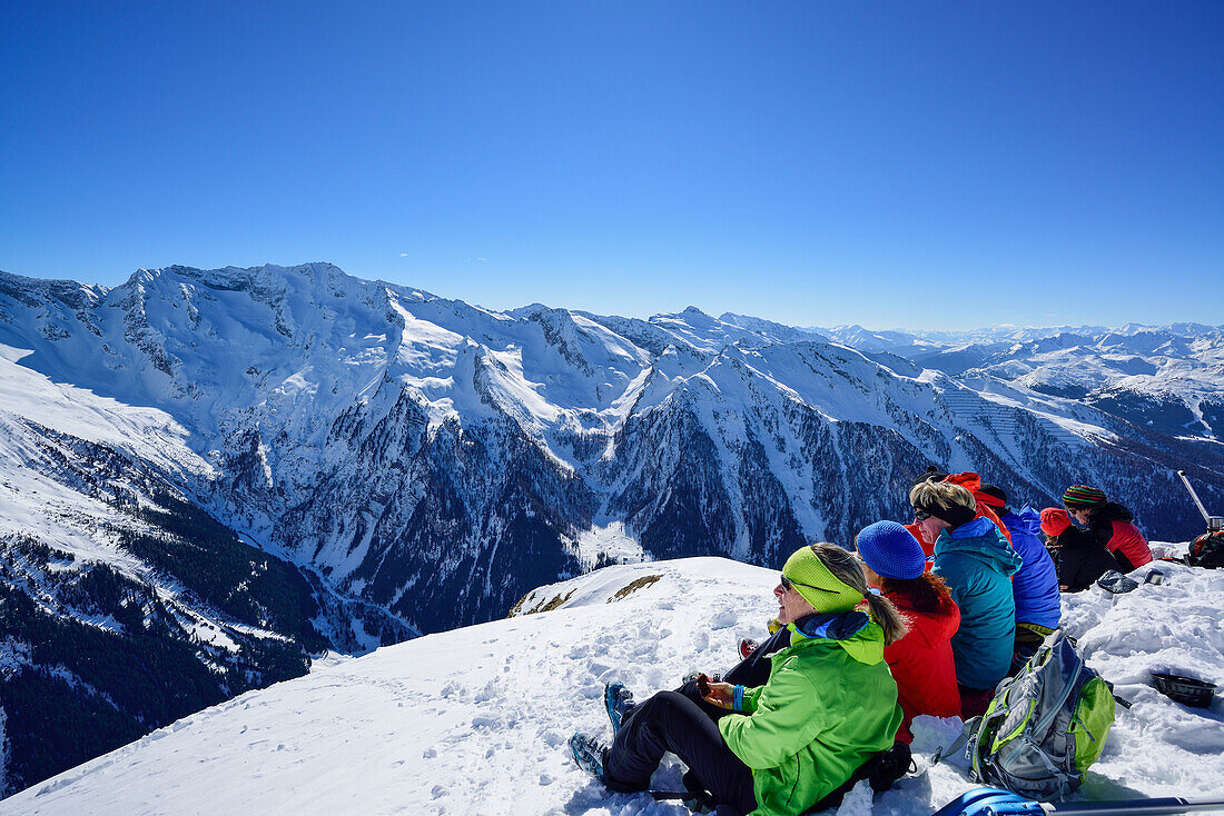 Several persons back-country skiing having a break on the summit of Gammerspitze and looking towards Zillertal Alps, Gammerspitze, valley of Schmirn, Zillertal Alps, Tyrol, Austria