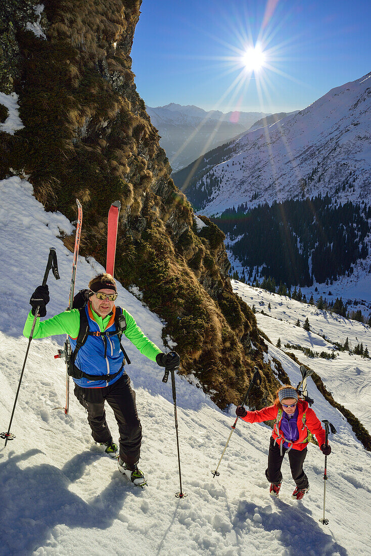 Two persons back-country skiing ascending through steep gully towards Schneespitze, Schneespitze, valley of Pflersch, Stubai Alps, South Tyrol, Italy