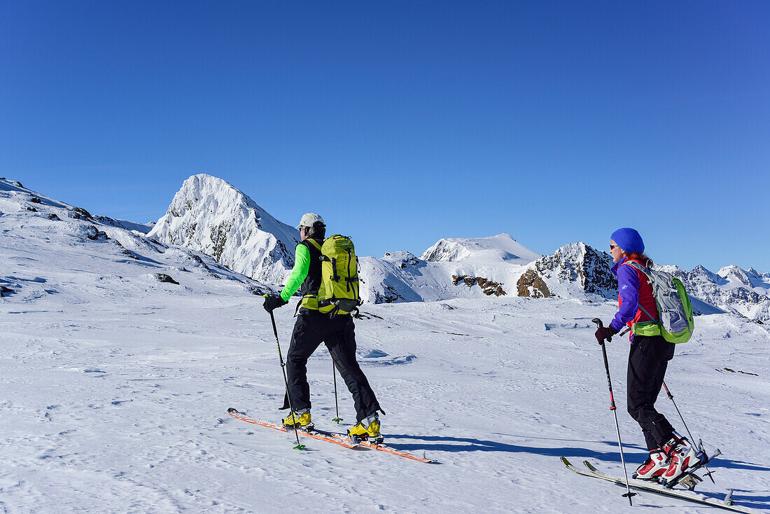 Man and woman back-country skiing ascending towards Schneespitze, Feuerstein in the background, Schneespitze, valley of Pflersch, Stubai Alps, South Tyrol, Italy