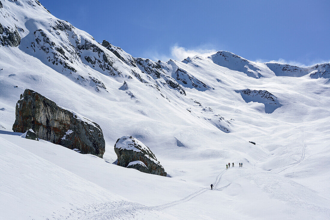 Several persons back-country skiing ascending towards Monte Faraut, Monte Faraut, Valle Varaita, Cottian Alps, Piedmont, Italy