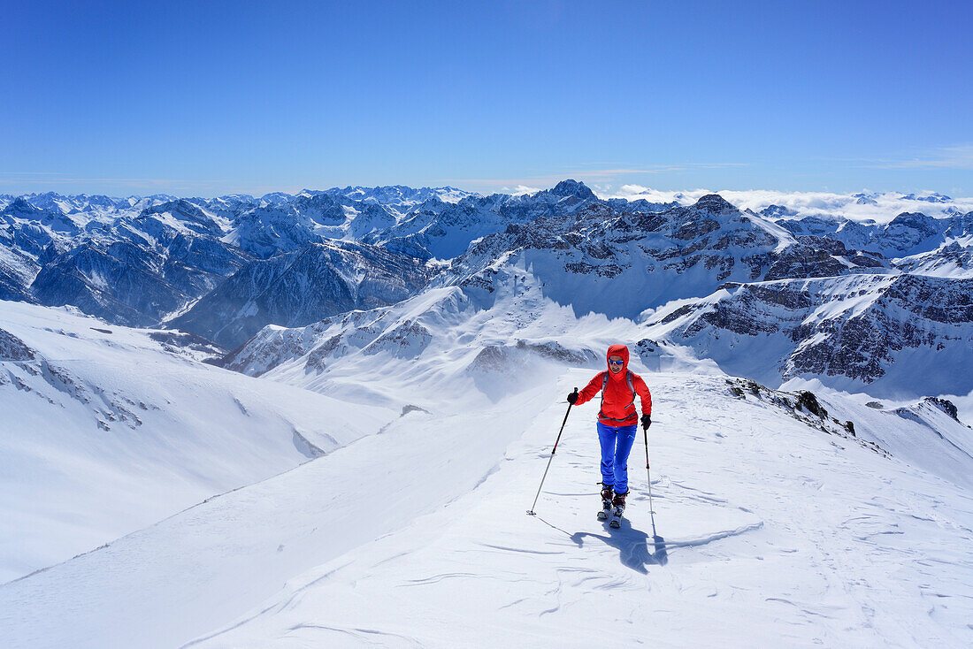 Woman back-country skiing ascending towards Monte Faraut, in the background Tete de Moise and Monte Cervet, Monte Faraut, Valle Varaita, Cottian Alps, Piedmont, Italy