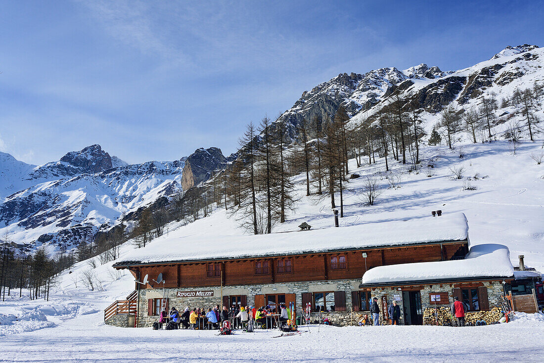 People sitting on the terrace of Rifugio Meleze, Valle Varaita, Cottian Alps, Piedmont, Italy