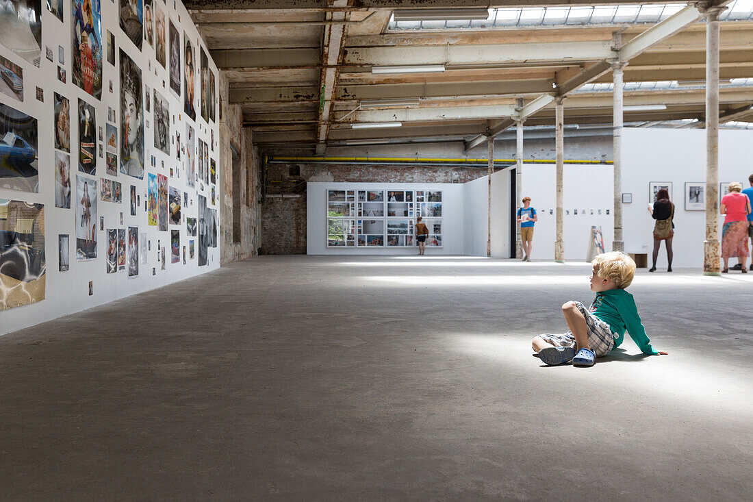 Boy looking at photo exhibition in an old factory, Leipzig, Saxony, Germany