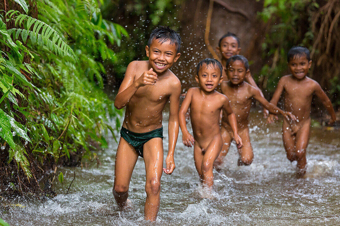 Kinder baden am Fuße des Vulkan Gunung Rinjani in einem Wasserkanal, Lombok, Indonesien, Asien