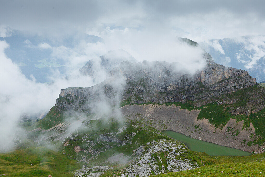 lake Grubasee with Grubalackenspitze mountain and fog and clouds, Rofan mountains, district Schwaz, Tyrol, Austria, Europe