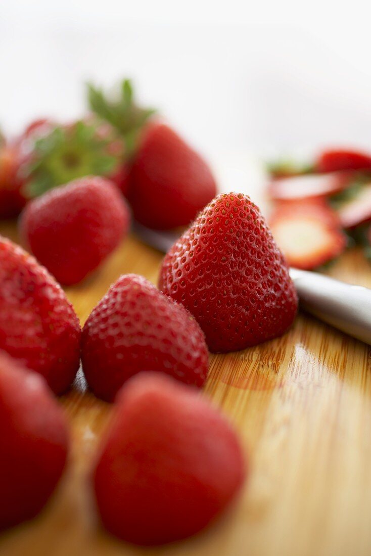 Frische Erdbeeren mit abgeschnittenem Stiel auf Schneidebrett