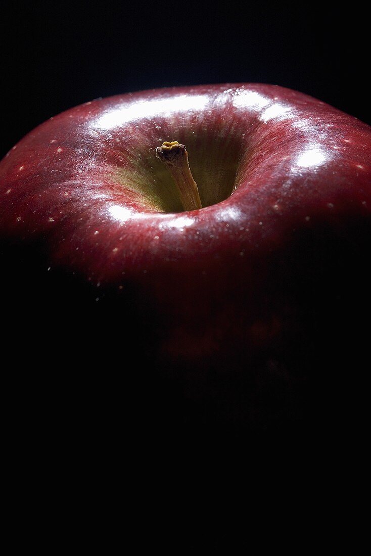 Ein einzelner roter Apfel vor schwarzem Hintergrund