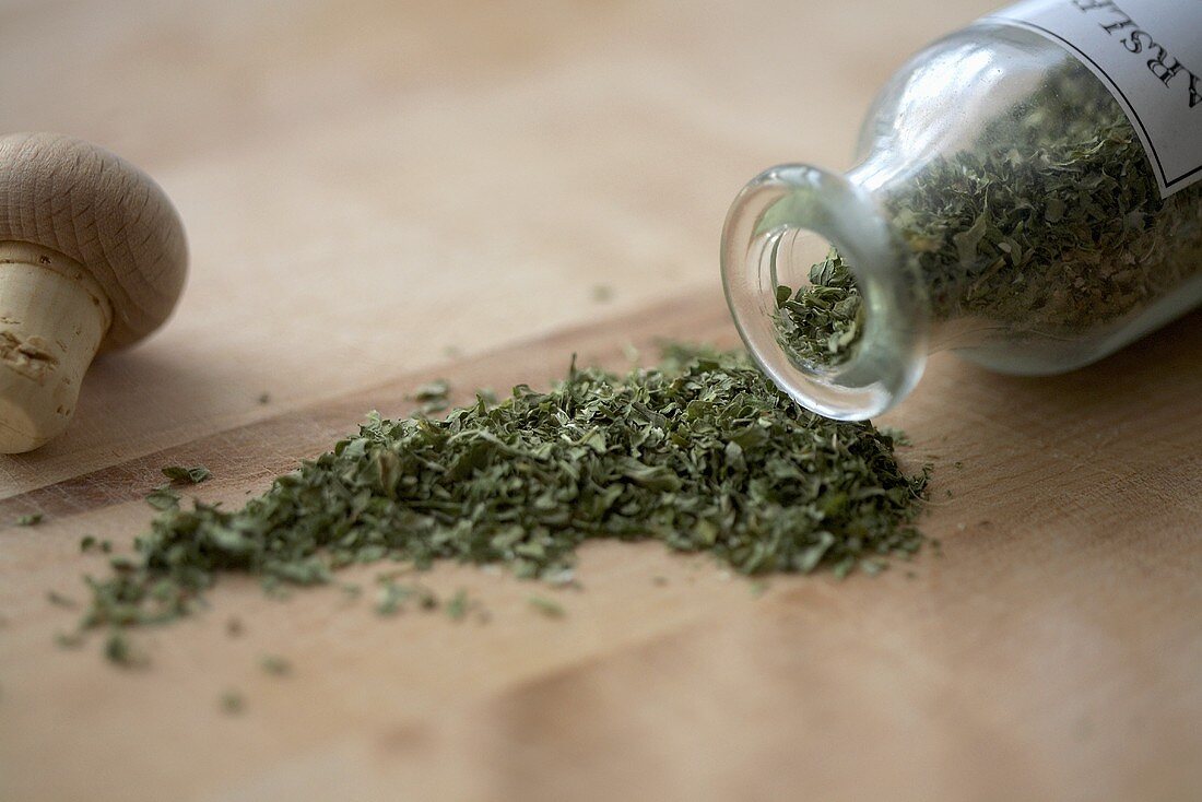 Dried Parsley Spilling From a Glass Bottle