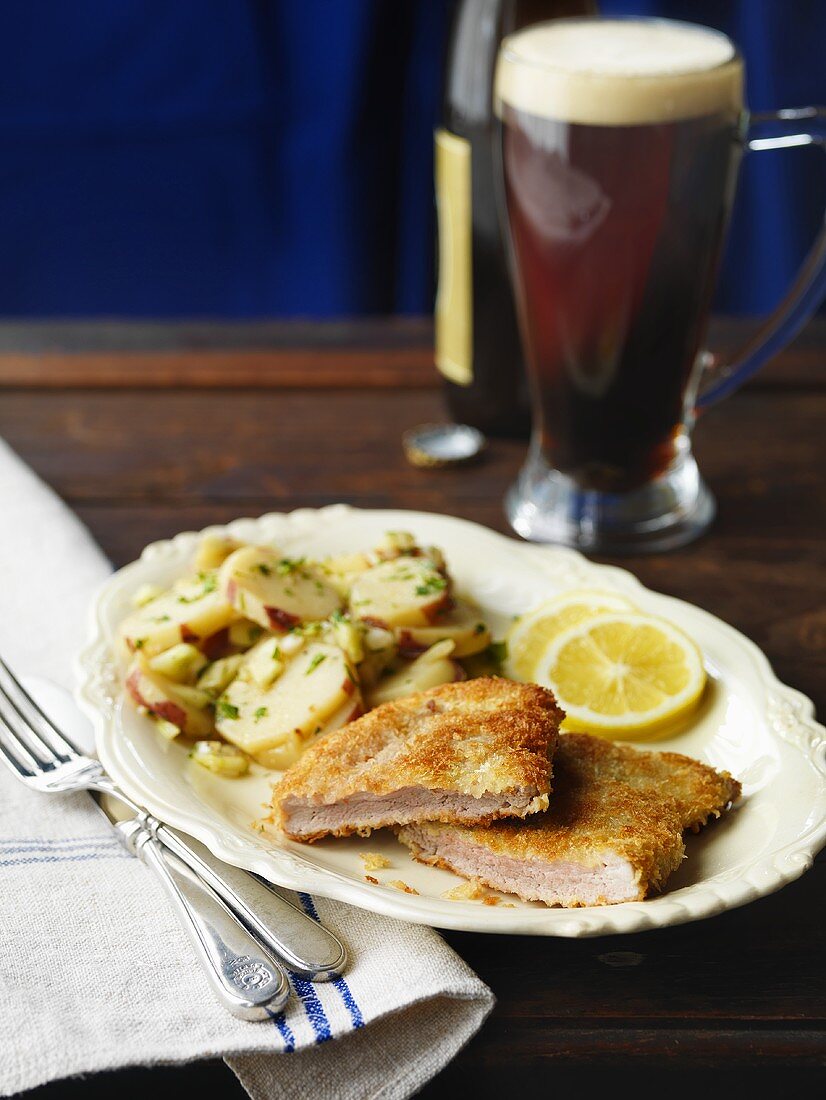 Breaded Pork Cutlet on a Plate With Potatoes; Beer