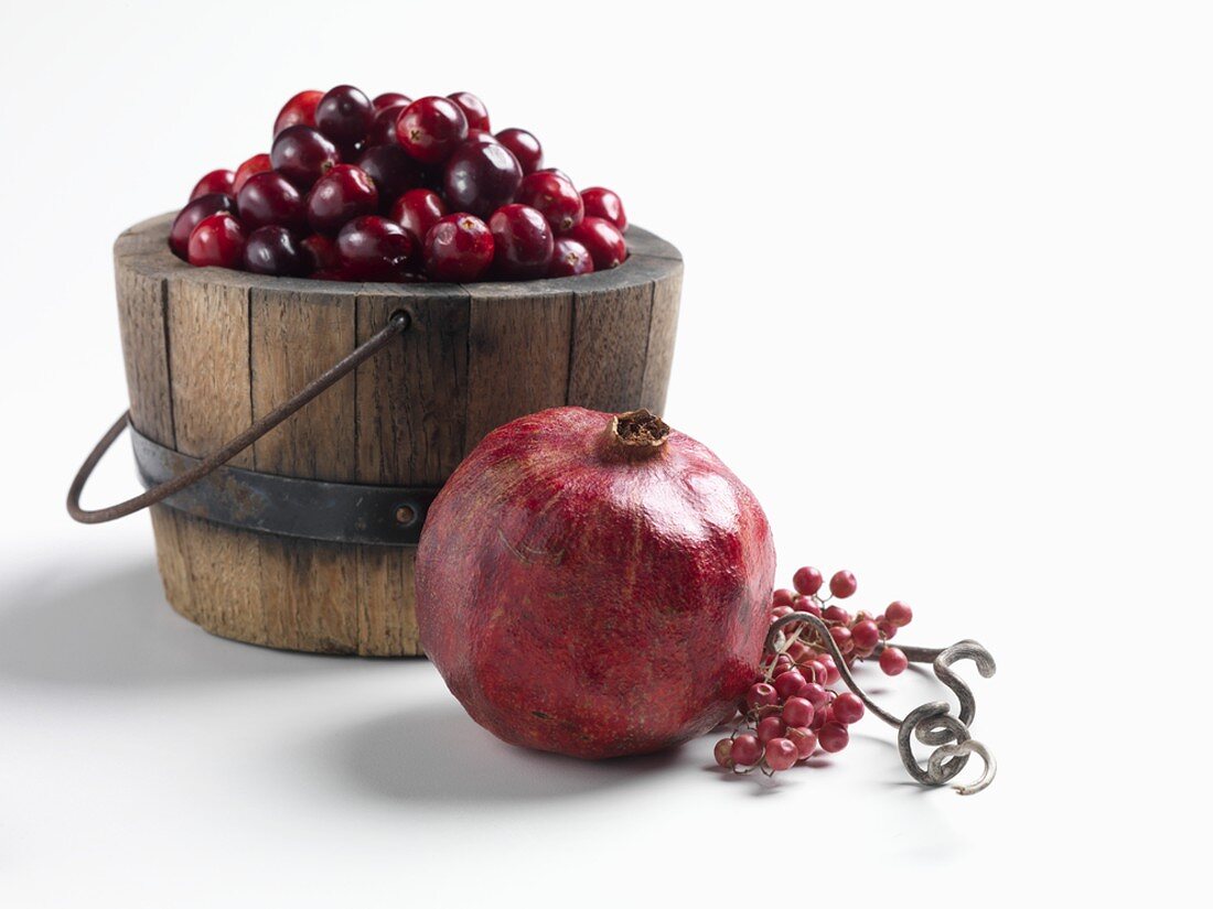 A Pomegranate, Cranberries and Pepper Berries on White