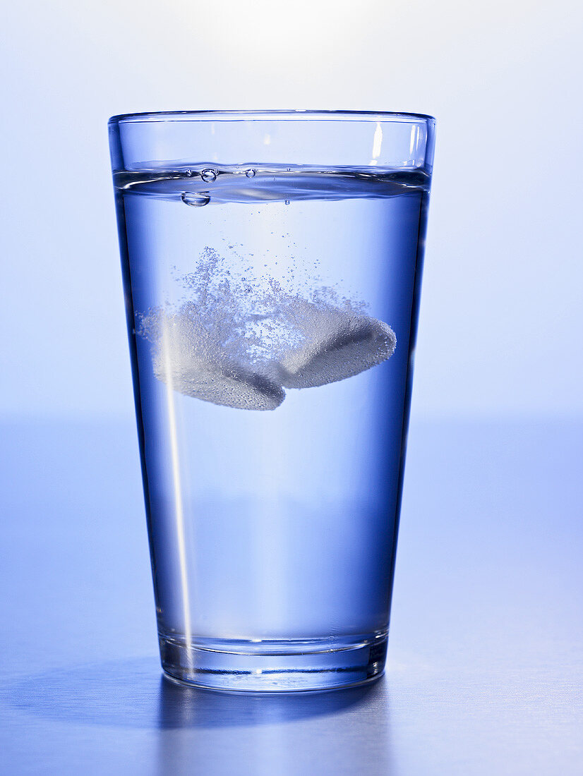 Zwei Brausetabletten in Glas Wasser