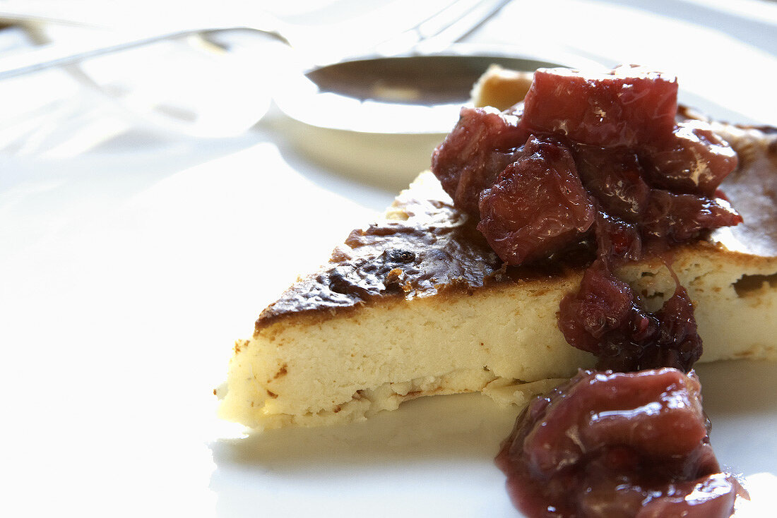 Stück Käsekuchen mit Rhabarberkompott