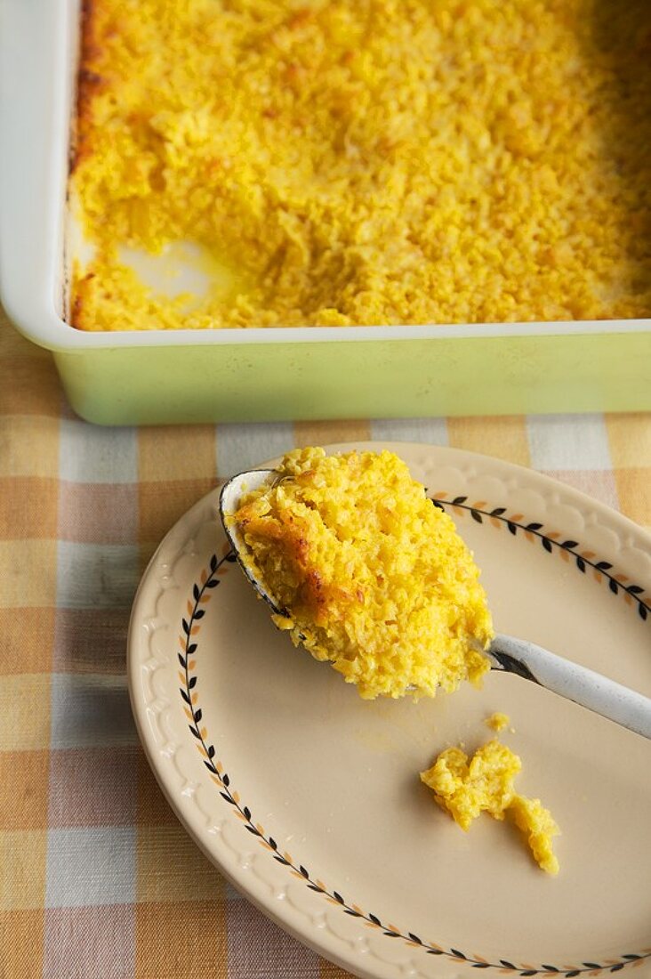 Corn Pudding on a Spoon with Baking Dish