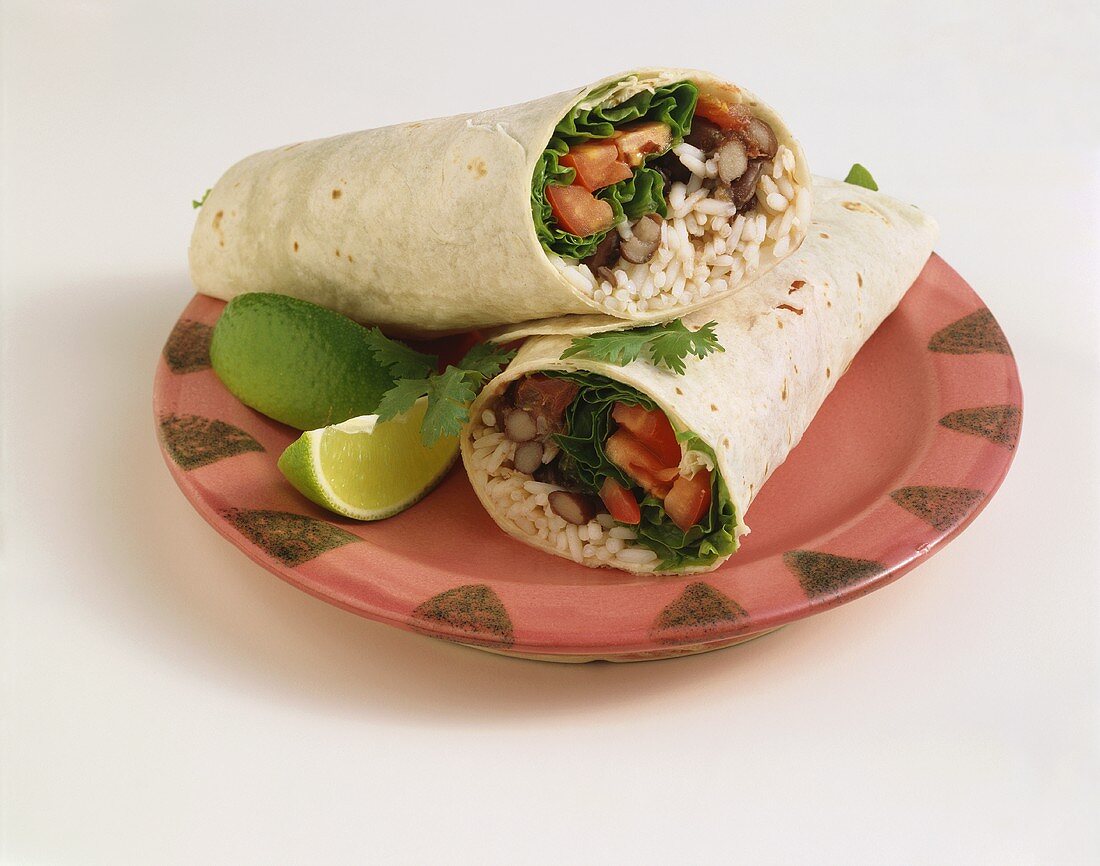 Vegetarian Wrap with Rice, Beans, Lettuce and Tomato, Halved on a Plate