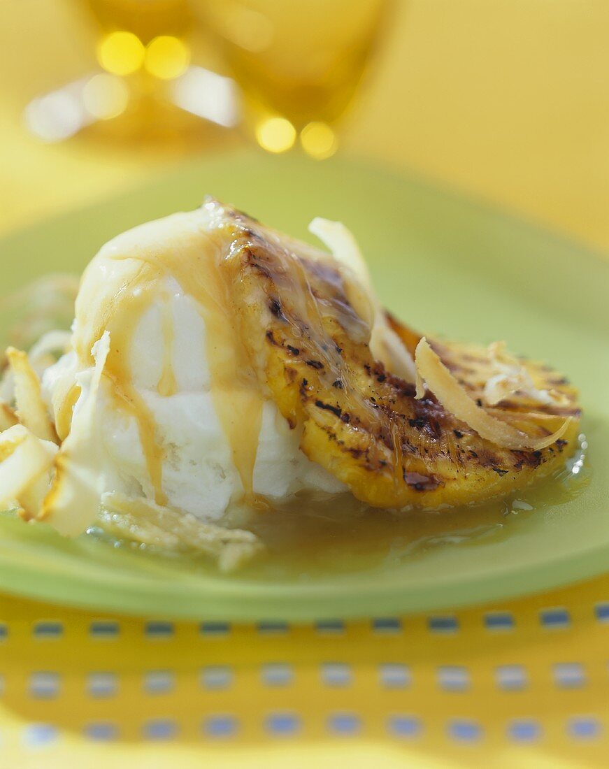 Slice of grilled pineapple with vanilla ice cream and caramel sauce