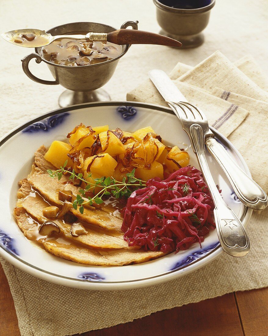 Schweinebratenscheiben mit Rotkohl, Kürbis und Pilzsauce