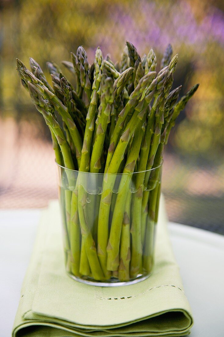 Fresh Asparagus Spears in a Large Glass of Water