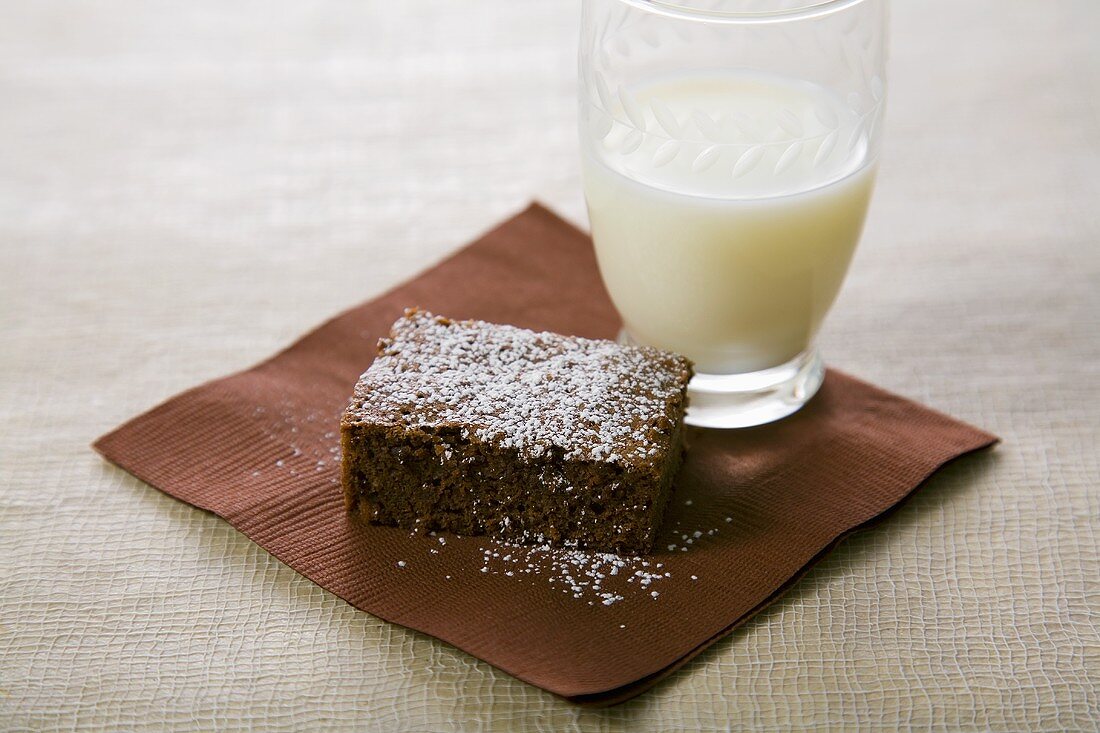 Brownie Topped with Powdered Sugar and a Glass of Milk