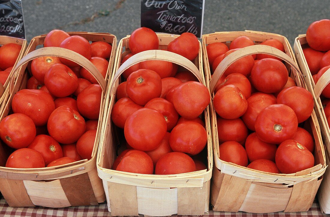 Mehrere Spankörbe mit frischen Tomaten auf einem Bauernmarkt